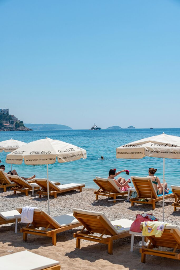 Relaxing beach scene with sunbeds and umbrellas on a clear, sunny day.